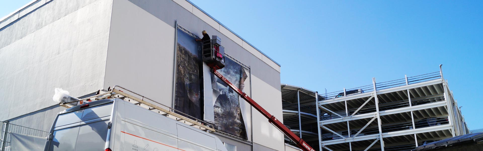 Befestigung eines Werbebanners an einer Fassade zur Darstellung von Fassadenwerbung