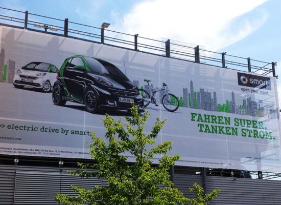 Großes Werbebanner an Gebäude für Fahrzeugwerbung.