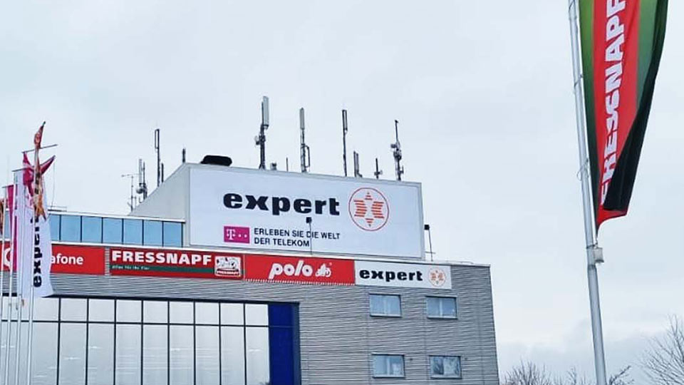 Außenwerbung: Ein Gebäude mit unterschiedlichen Arten der Außenwerbung wie Bannersysteme, Werbeschilder und Fahnen