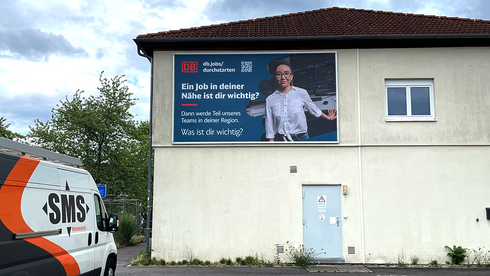 Fassadenwerbung Hauptbahnhof Neustadt a.d. Weinstraße mit dem Kederrahmen+ für die Deutsche Bahn. Titelbild für soziale Netzwerke.
