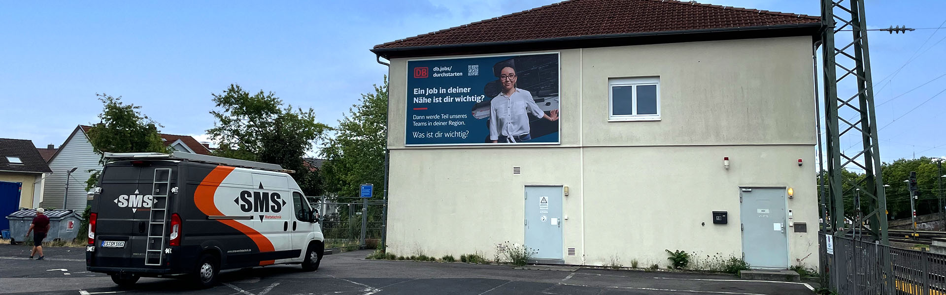 Fassadenwerbung Hauptbahnhof Neustadt an der Weinstraße mit dem Kederrahmen+ für die Deutsche Bahn. Frontalansicht aus etwa 50 Meter Distanz.