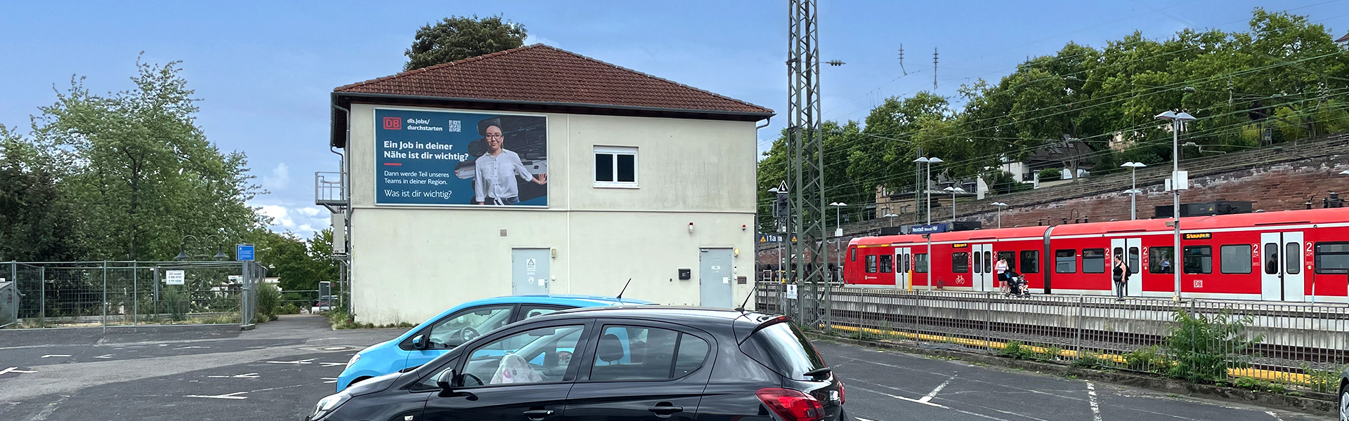 Komplettansicht der Fassadenwerbung an einem Gebäude des Hauptbahnhofes in Neustadt an der Weinstraße für die Deutsche Bahn.
