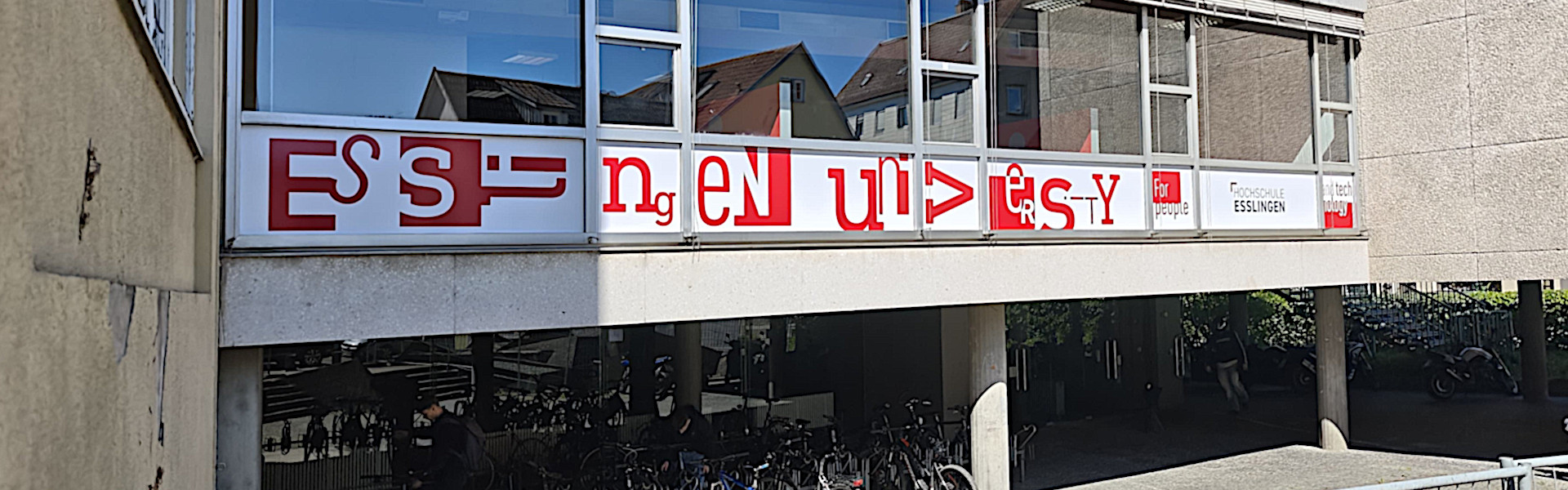 Beschriftung mit Folien am Gebäudedurchgang der Hochschule. Ansicht von links.