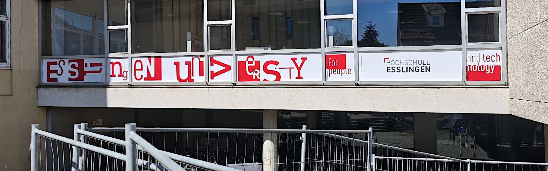 Beschriftung mit Folien am Gebäudedurchgang der Hochschule. Ansicht von rechts.