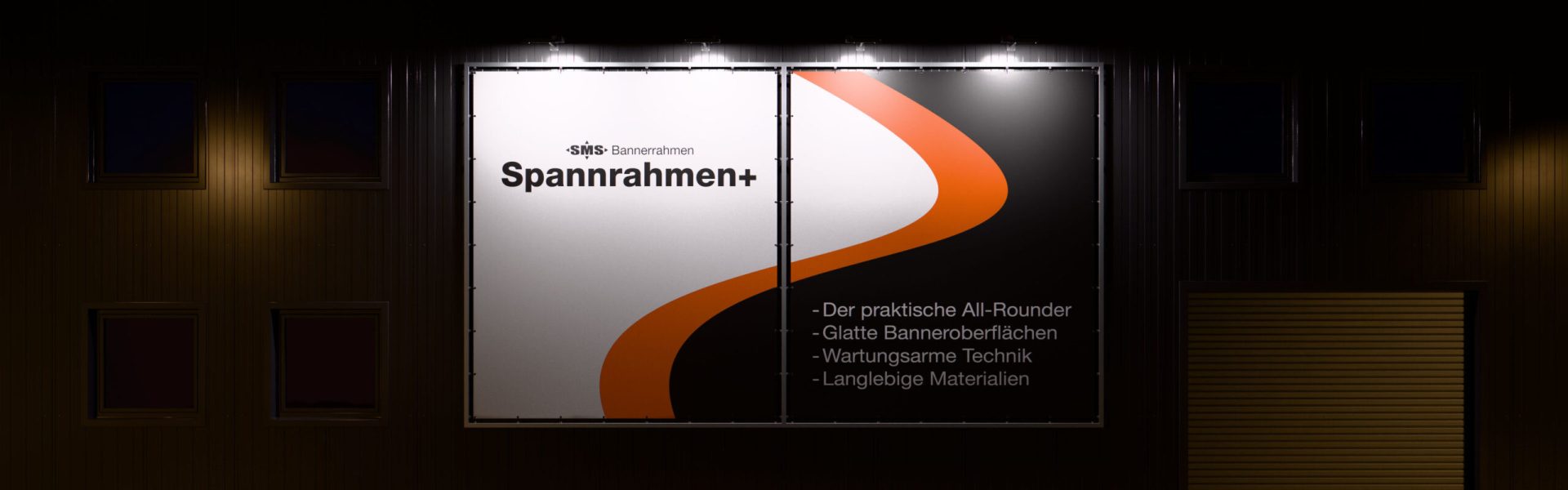 Spannrahmen+: Beispiel eines modular mehrteiligen Systems. Frontansicht bei Nacht mit Strahlerbeleuchtung.